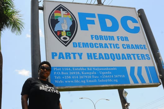 UGANDA, Kampala: A supporter of former Uganda's presidential candidate and opposition leader Kizza Besigye is seen in front of FDC's placard, during the Free my vote campaign launch in Kampala, on March 15, 2016. The Free my vote campaign, that includes praying every Tuesday around the country, is organized by the FDC (Forum for Democratic Change) in protest of the outcome of the February 18 presidential election and the subsequent home detention of the party's presidential candidate Dr Kizza Besigye who has been under police siege since the declaration of presidential results.