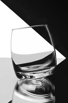 Empty glass for whiskey round bottom, black and white background. 