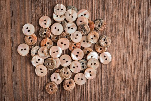 Set of different colored buttons over rustic wooden texture.Top view with copy space.