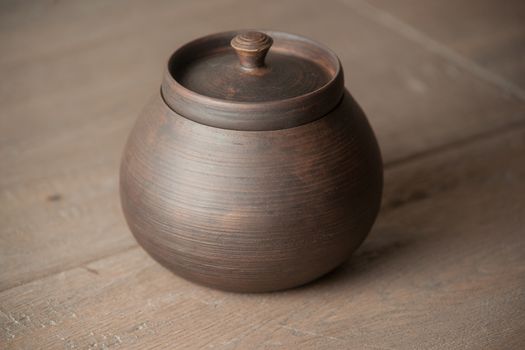 Traditional handcrafted brown pot with a cap