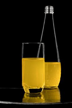 Soft drink in bottle and glass, vintage lacquered surface and a black background