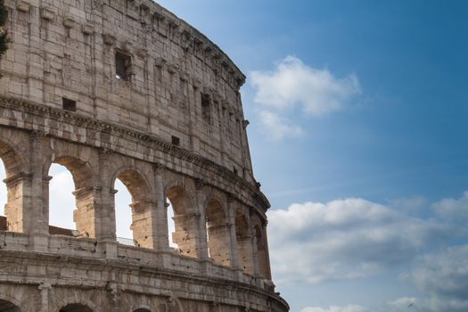 Colosseum as an iconic symbol of Imperial Rome. Blue sky with clouds.