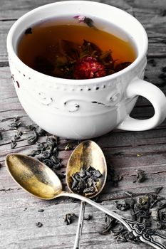 Bright cup with custard tea and two spoons on a wooden board