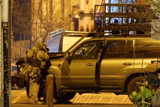 BELGIUM, Brussels: A member of the special forces takes position behind a car near the site of a shooting in the southern Forest district of Brussels on March 15, 2016. Belgian and French police launched a huge manhunt for two suspects in Brussels after gunmen opened fire, wounding three officers, during a joint anti-terror operation linked to the Paris attacks.