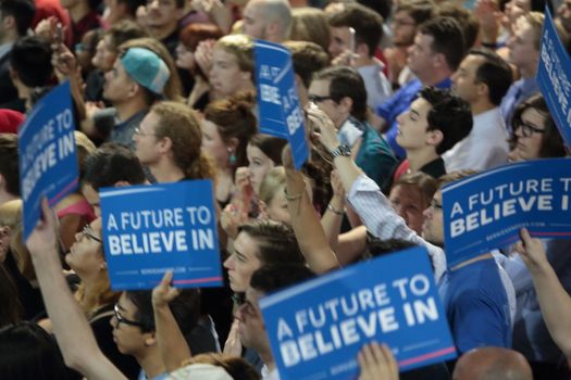 UNITED STATES, Phoenix: Members of the crowd show their support for Democratic presidential candidate Sen. Bernie Sanders at the Phoenix Convention Center during a campaign rally on March 15, 2016 in Phoenix, Arizona. Hillary Clinton won the Democratic primary elections in Florida, North Carolina and Ohio, while Missouri and Illinois remain tight races.