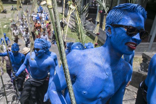 INDONESIA, Gianyar, Bali: Young members of the village community walk around the village with their bodies painted during the Grebeg ritual, on March 16, 2016, in Tegallalang village, Gianyar, Bali, Indonesia. During the biannual ritual, young members of 