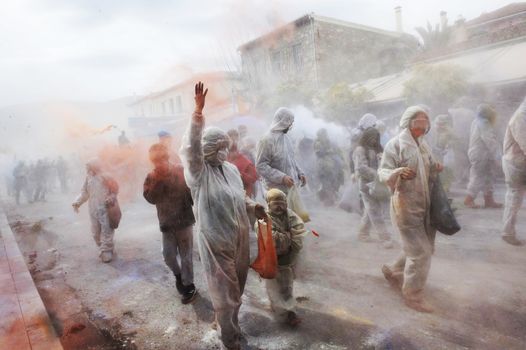 GREECE, Galaxidi: People walk through Galaxidi covered with flour on March 14, 2016. The battle takes place every year on 'Clean Monday', which marks the beginning of the Christian lent festival.The coastal town has observed this festive event which dates back to the mid 19th century. 