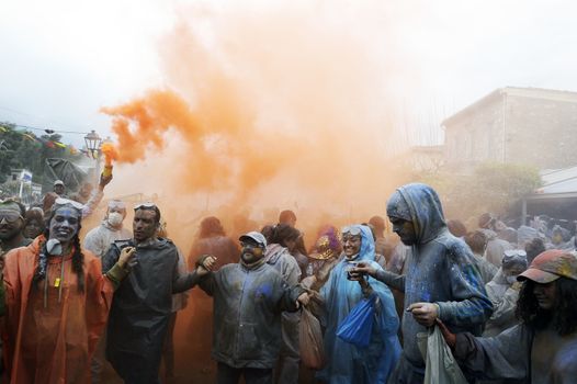 GREECE, Galaxidi: People hold hands and light smoke canisters as part of the annual flour battle on March 14, 2016. The battle takes place every year on 'Clean Monday', which marks the beginning of the Christian lent festival.The coastal town has observed this festive event which dates back to the mid 19th century. 
