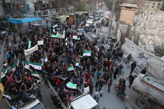 SYRIA, Saqba: Hundreds of Syrians hold a pre-Baath Syrian flag, that was adopted by the Syrian revolution during the uprising, on March 16, 2016 in Saqba, near Damascus, southern Syria, during a protest to mark the fifth anniversary of Syria's revolution. The conflict began with anti-regime protests in mid-March 2011 and spiralled into a bloody war after a harsh government crackdown on demonstrators. 