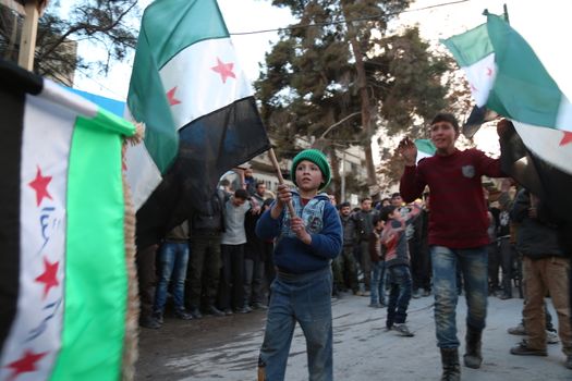 SYRIA, Saqba: A child holds a pre-Baath Syrian flag, that was adopted by the Syrian revolution during the uprising, on March 16, 2016 in Saqba, near Damascus, southern Syria, during a protest to mark the fifth anniversary of Syria's revolution. The conflict began with anti-regime protests in mid-March 2011 and spiralled into a bloody war after a harsh government crackdown on demonstrators. 