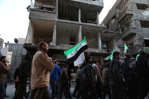 SYRIA, Saqba: Hundreds of Syrians hold a pre-Baath Syrian flag, that was adopted by the Syrian revolution during the uprising, on March 16, 2016 in Saqba, near Damascus, southern Syria, during a protest to mark the fifth anniversary of Syria's revolution. The conflict began with anti-regime protests in mid-March 2011 and spiralled into a bloody war after a harsh government crackdown on demonstrators. 