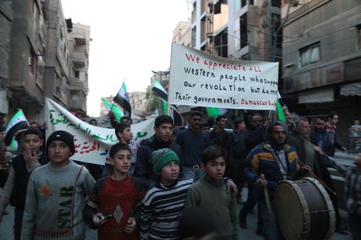 SYRIA, Saqba: Hundreds of Syrians hold a pre-Baath Syrian flag, that was adopted by the Syrian revolution during the uprising, on March 16, 2016 in Saqba, near Damascus, southern Syria, during a protest to mark the fifth anniversary of Syria's revolution. The conflict began with anti-regime protests in mid-March 2011 and spiralled into a bloody war after a harsh government crackdown on demonstrators. 