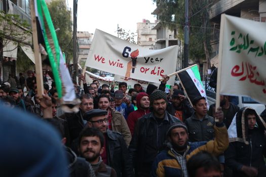 SYRIA, Saqba: Hundreds of Syrians hold a pre-Baath Syrian flag, that was adopted by the Syrian revolution during the uprising, on March 16, 2016 in Saqba, near Damascus, southern Syria, during a protest to mark the fifth anniversary of Syria's revolution. The conflict began with anti-regime protests in mid-March 2011 and spiralled into a bloody war after a harsh government crackdown on demonstrators. 