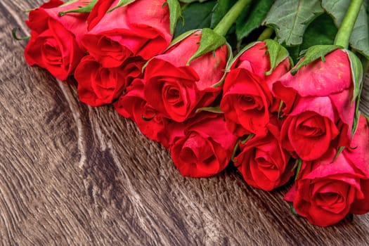Red roses on a brown wooden background