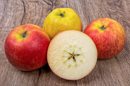 Ripe apples on a brown wooden background