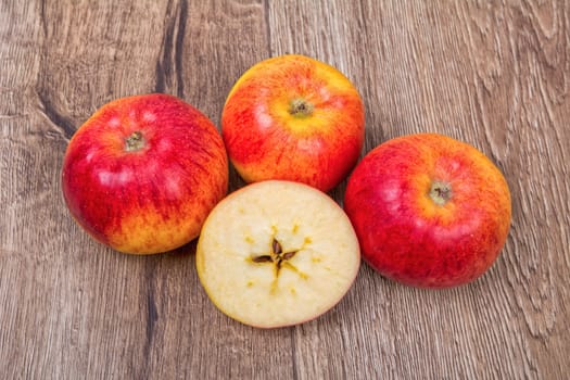 Ripe apples on a brown wooden background