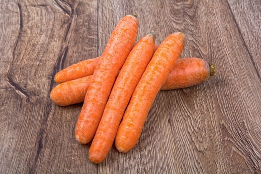 Red carrots on a brown wooden background