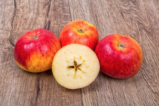 Ripe apples on a brown wooden background