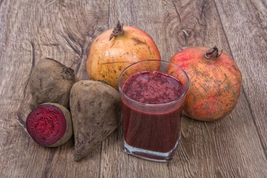 Blended dark red smoothie with ingredients on wooden table