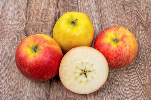 Ripe apples on a brown wooden background