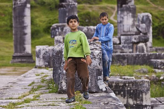 SARDIS, TURKEY – APRIL 20: Two unidentified Turkish boys playing in the ruins of Sardis on April 20, 2012 in Istanbul, Turkey. 