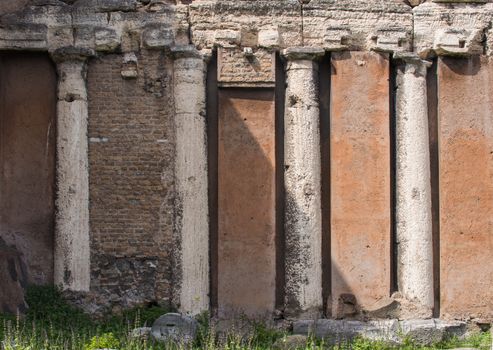 Typical orange color of the roman architecture, with four old columns from the original building. Rome, Italy