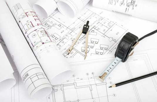 Architecture plan and rolls of blueprints with meter and divider. Building concept