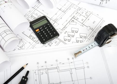 Architecture plan and rolls of blueprints with meter and calculator. Building concept