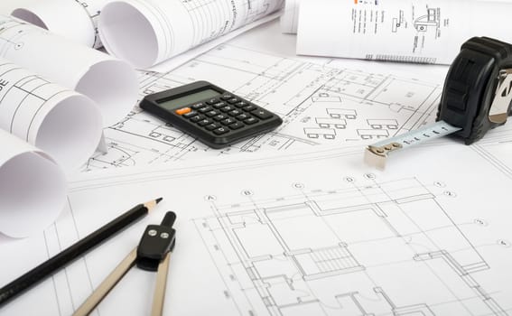 Architecture plan and rolls of blueprints with meter and calculator. Building concept