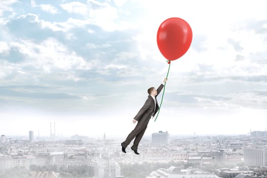 Businessman holding balloon and flying above city, business concept