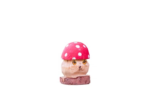 Fly agaric carved out of wood in front of white background.