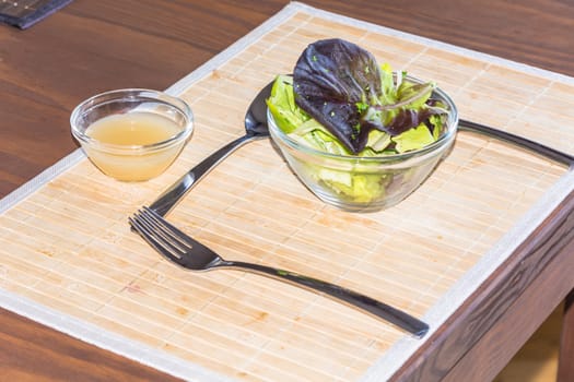 A table laid with cutlery, salad and dessert.