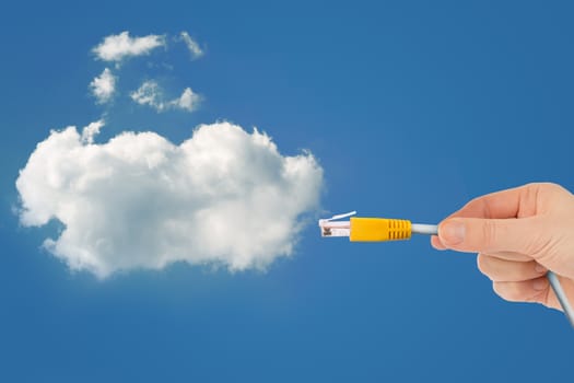 Hand holding computer cabel with cloud in sky, technology concept