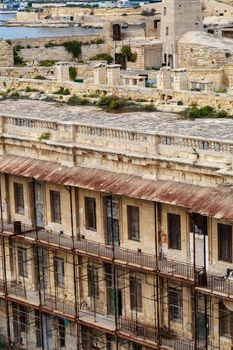 Detailed view of Valletta city in Malta island with limestone buildings from medieval times, on cloudy sky background.