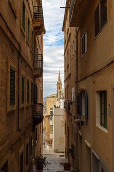 Detailed view of Valletta city in Malta island with limestone buildings from medieval times, on cloudy sky background.