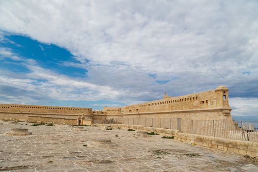 Detailed view of Valletta city in Malta island with limestone buildings from medieval times, on cloudy sky background.