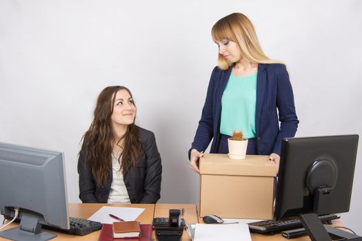 Office worker with a smile looking at the dismissed colleague