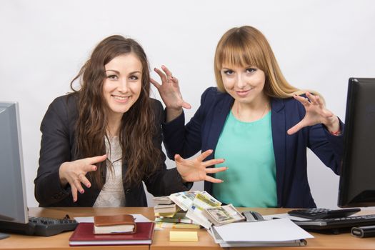 for office table two women collaborators are thrown on a pile of money