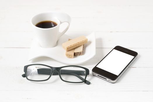 coffee cup with wafer,phone,eyeglasses on white wood background