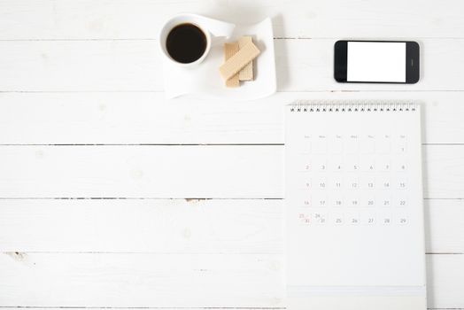 coffee cup with wafer,phone,calendar on white wood background