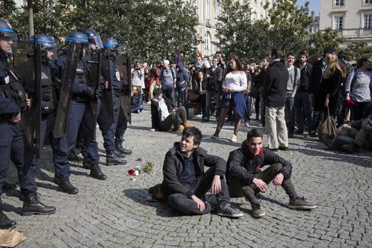 FRANCE, Paris: Two young men sit on a square next to policemen as high school students and youths demonstrate in front of Rennes' town hall, western France,  during a protest march opposing the government's labour reforms on March 17, 2016. The contested reform is designed to inject more flexibility into the labour market by dropping key measures that would have benefited smaller companies. In a significant change from the original text, French Prime minister said on Monday that small and medium-sized companies would not be able to unilaterally introduce flexible work practices into their working week.