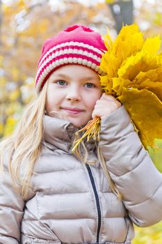 Photo of girl with bouquet from sheets in autumn