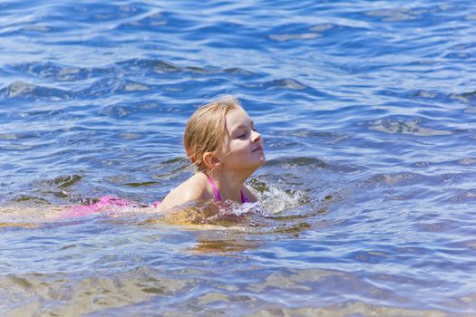 Swimming smiling cute girl seven years old