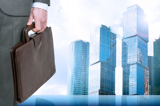 Businessman with briefcase and cityscape background, business concept