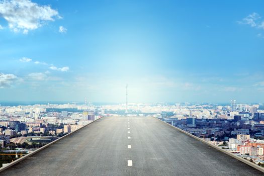 Road over city in blue sky and sun
