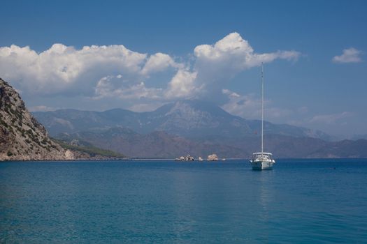 Grey mountains and blue sea and yaht in Asia Minor
