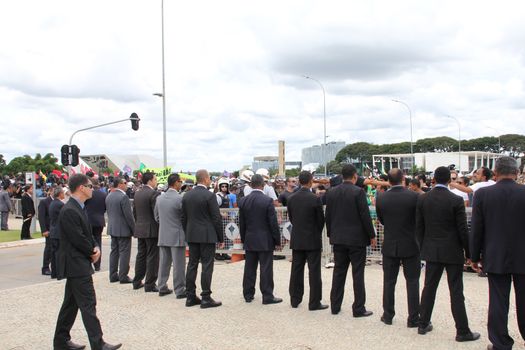 BRAZIL, Brasilia: Security officials stand in a line outside the Presidential Palace in Brasilia, Brazil on March 17, 2016 after ex-president Luiz Inácio Lula da Silva was appointed to the cabinet.The decision resulted in protests throughout the country, with some thinking that the appointment of the former president was an attempt to save him from charges in a corruption scandal.