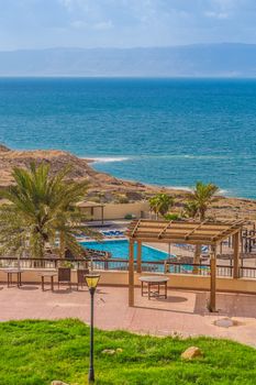 Hotel swimming pool on the shores of the Dead Sea in Jordan. In pure sea water visible salt crystals. On the other side of the visible area of Israel.