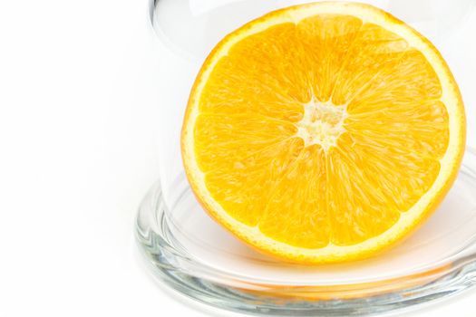 Slice a fresh juicy  round orange in a transparent glass bowl isolated on white 