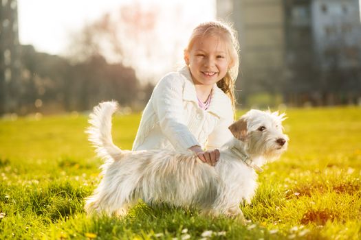 Little girl caress with her puppy dog in the park